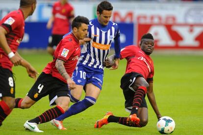 El delantero alavesista Borja viguera disputa el balón a dos jugadores del Mallorca.