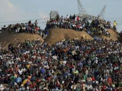 Familiares y miembros del asentamiento improvisado de Wonderkop en las colinas del lugar donde sucedió la masacre para oficiar un servicio religioso en honor a los mineros de la empresa Lonmin, que fueron abatidos por la Policía sudafricana en el campamento minero de Marikana. EFE/Archivo