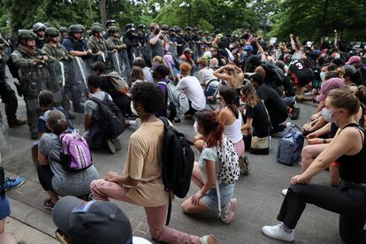 Los manifestantes hincan la rodilla frente a as fuerzas de seguridad cerca de la Casa Blanca, el miércoles en Washington.