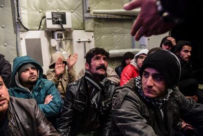 Migrantes sirios esperan a bordo del buque de la Guardia Costera de Turquía tras ser rescatados en el mar Egeo cuando intentaban llegar a la isla griega de Chios.