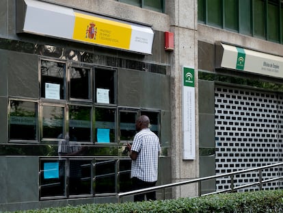 Un hombre lee la información en la puerta de la oficina de empleo de Huerta de la Salud (Sevilla).