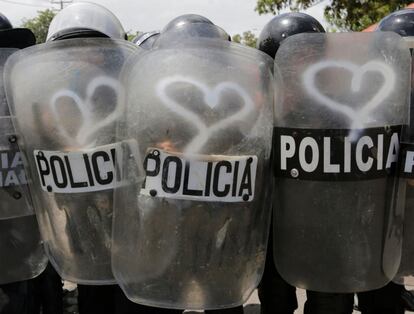 Graffitis en forma de corazón hechos por activistas en los escudos de la policía antidisturbios durante una protesta contra el gobierno del presidente nicaragüense Daniel Ortega en Managua.