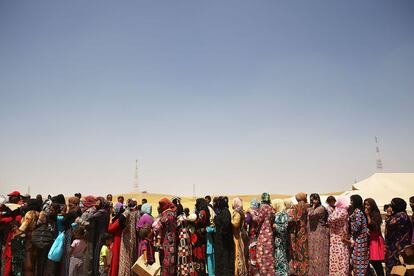 Mujeres iraquíes que han huído de los combates en Mosul esperan recibir alimentos en el campamento de desplazados de Khazair.