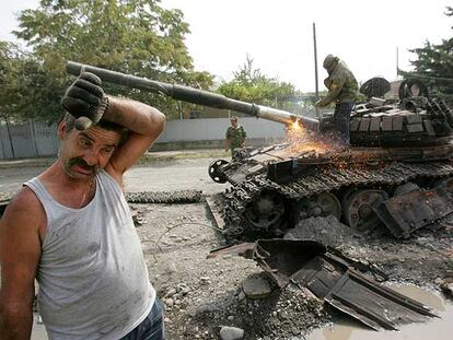 Un trabajador corta con un soplete el cañón de un tanque georgiano destrozado durante los enfrentamientos de este mes en Osetia del Sur.