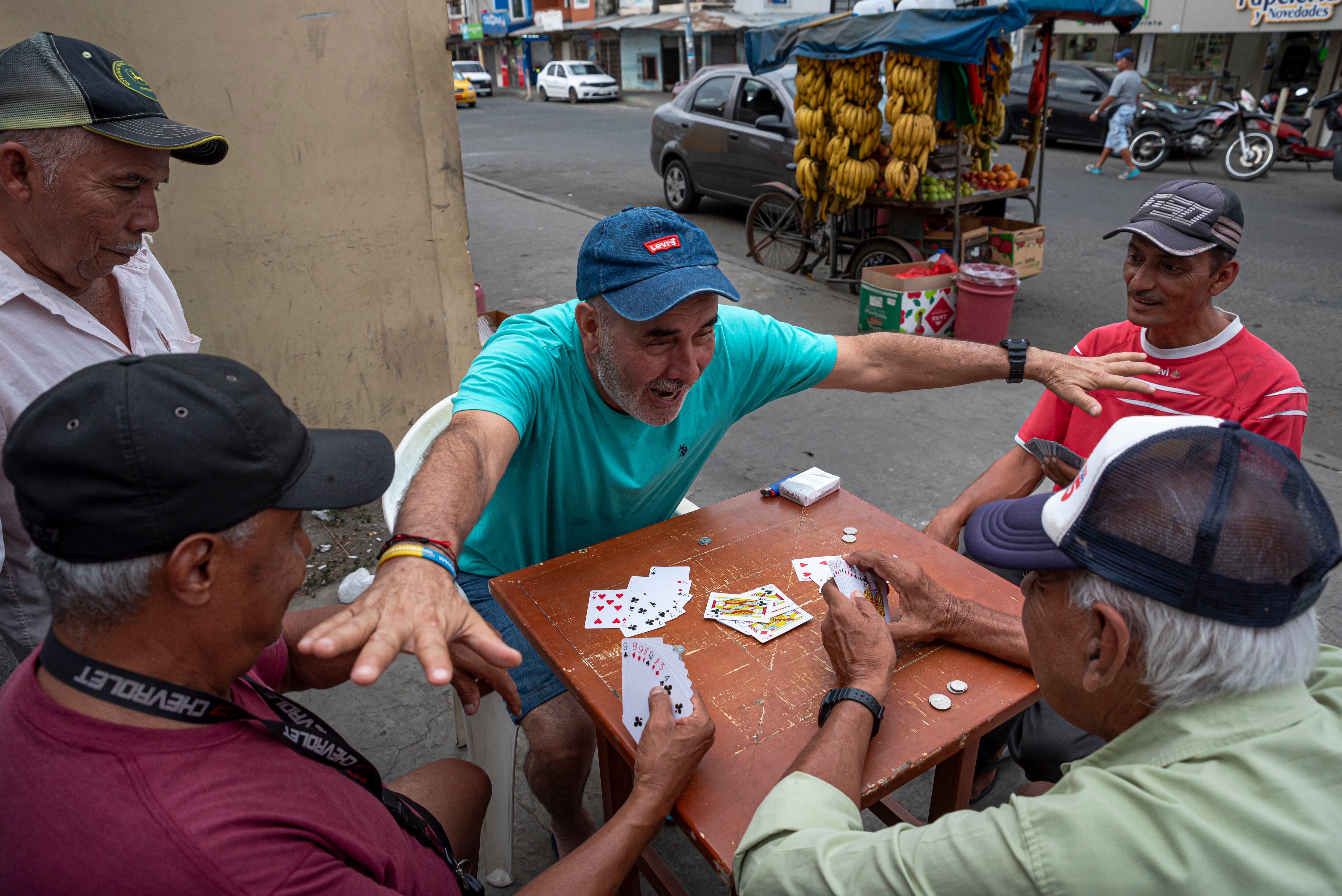 Vecinos del barrio Cuba juegan cartas en la avenida principal.