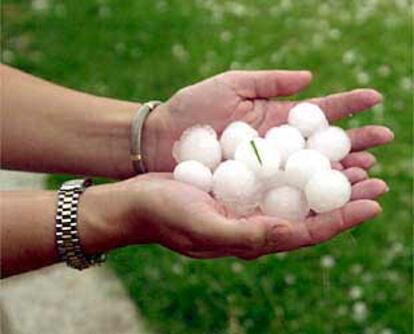 Un vecino sostiene un montón de granizo caído en Pedrezuela.