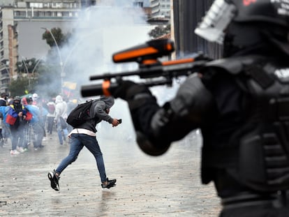 Un agente de la policía antidisturbios dispara hacia los manifestantes en la plaza Bolívar de Bogotá en las protestas de la huelga nacional, este miércoles.