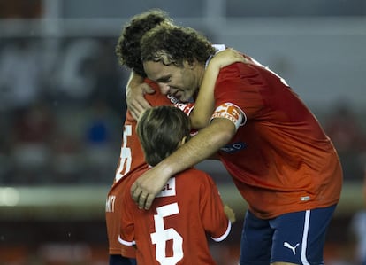 Milito abraza a sus hijos Lucas y Santiago.