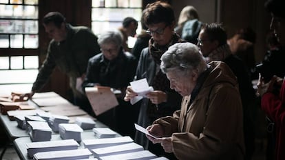 Un grupo de votantes escoge papeletas electorales en la Universidad de Barcelona.