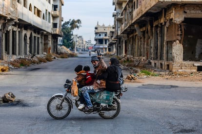 Una familia en motocicleta, por una calle salpicada de ruinas en Deraa, la cuna de la revolución siria contra el régimen de Bachar el Asad, el pasado jueves.