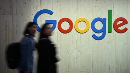 Dos personas pasan junto al logo de Google, en Alemania.