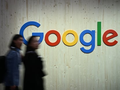 Two people walk past the Google logo during a fair in Hanover, Germany, on April 22.