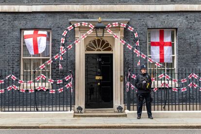 Un agente en el exterior de Downing Street, decorado con las banderas de Inglaterra. El primer ministro británico, Boris Johnson, envió este domingo "la mejor de las suertes" a Inglaterra de cara a la final de la Eurocopa.