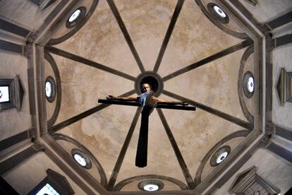 En un plano contrapicado, se aprecia una imagen de un Cristo crucificado, del artista italiano Miguel Ángel reubicado en una posición que facilita su visión desde todos los puntos de la basílica de el Espíritu Santo, en Florencia (Italia).