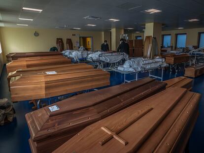 Funcionários de uma funerária preparam caixões em Bérgamo.