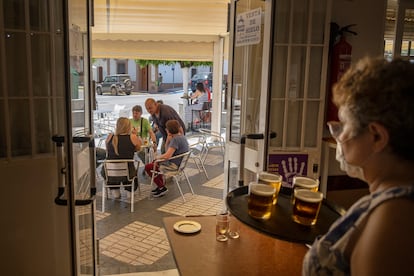 Una camarera sirve consumiciones en la terraza de un bar en Almensilla (Sevilla).