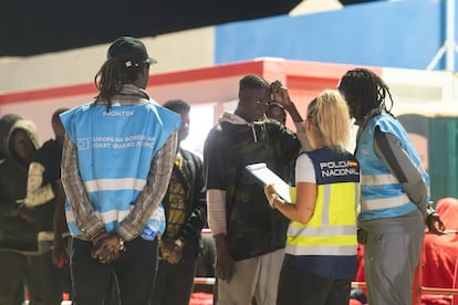Agentes de Frontex y del Cuerpo Nacional de Policía hablan con un hombre rescatado de una patera el 28 de junio en el puerto de Gran Tarajal de Fuerteventura.