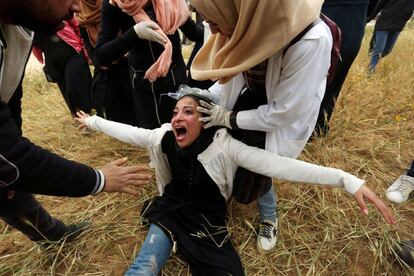 Desde hace un año las protestas frente a la frontera han desatado fuertes tensiones en la zona. En la imagen, una mujer palestina recibe ayuda tras el lanzamiento de gas lacrimógeno durante las protestas.
