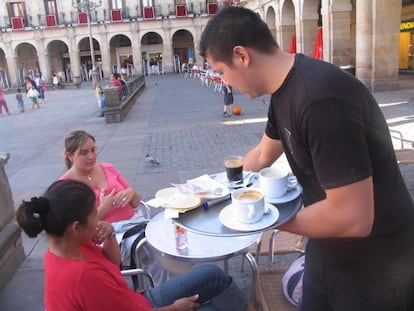 Un camarero sirviendo en una terraza.