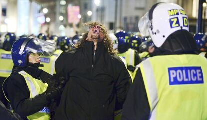 La policía detiene a un hombre en la Plaza de Trafalgar, en Londres, durante la manifestación de los enmascarados.