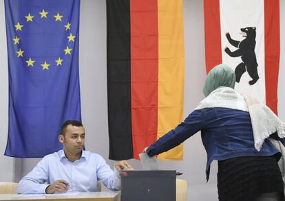 Una mujer deja su voto en un colegio electoral en Berlín (Alemania).