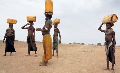 Mujeres de la tribu nyagamtom transportan agua en África.