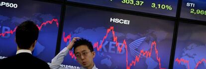 Corredores de bolsa conversan junto a una pantalla que muestra información bursátil en Seúl (Corea del Sur). EFE/Archivo
