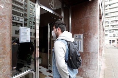 A building resident reads a notice informing about the death of a neighbor.