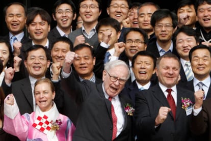 El magnate Warren Buffett, con empleados suyos, en una de sus empresas en Asia.