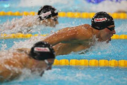 Ryan Lochte, destacado entre dos rivales.