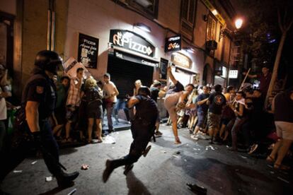 Un policía y un manifestante se enfrentan en una calle cercana a la puerta del Sol.