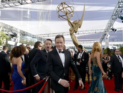 Bryan Cranston, a su llegada a la alfombra roja de los premios Emmy de 2013. A sus espaldas, el intérprete Aaron Paul, su compañero en la serie ‘Breaking Bad’, que esa noche se convirtió en una de las grandes ganadoras.