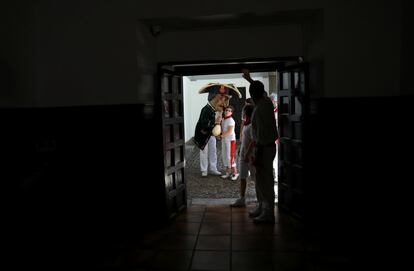 Un Cabezudo se acerca a un niño para susurrarle algo antes del inicio de la Comparsa de "Gigantes y Cabezudos", durante el festival de San Fermín.