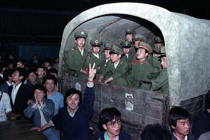 Em 20 de maio de 1989, o governo chinês decretou o estado de exceção e as avenidas da capital começaram a ser preenchidas com veículos blindados e caminhões carregados de soldados. Na foto, vários cidadãos cercam um comboio de 4.000 soldados em um subúrbio da cidade para impedir que eles cheguem à Praça Tiananmen em 20 de maio de 1989.