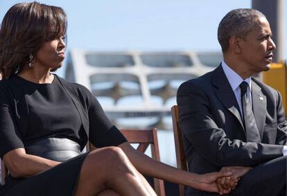 Michelle Obama y el expresidente Obama se dan la mano en marzo de 2015.