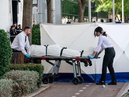 Dos trabajadores de la funeraria levantan el cadáver del joven, en las inmediaciones de la discoteca Caña Brava.