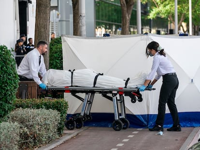 Dos trabajadores de la funeraria levantan el cadáver del joven, en las inmediaciones de la discoteca Caña Brava.