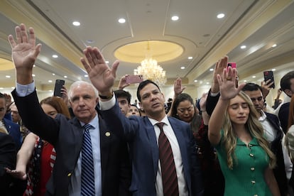 Asistentes rezan por el candidato Donald Trump durante el encuentro con líderes latinos, este martes en Doral, Florida.