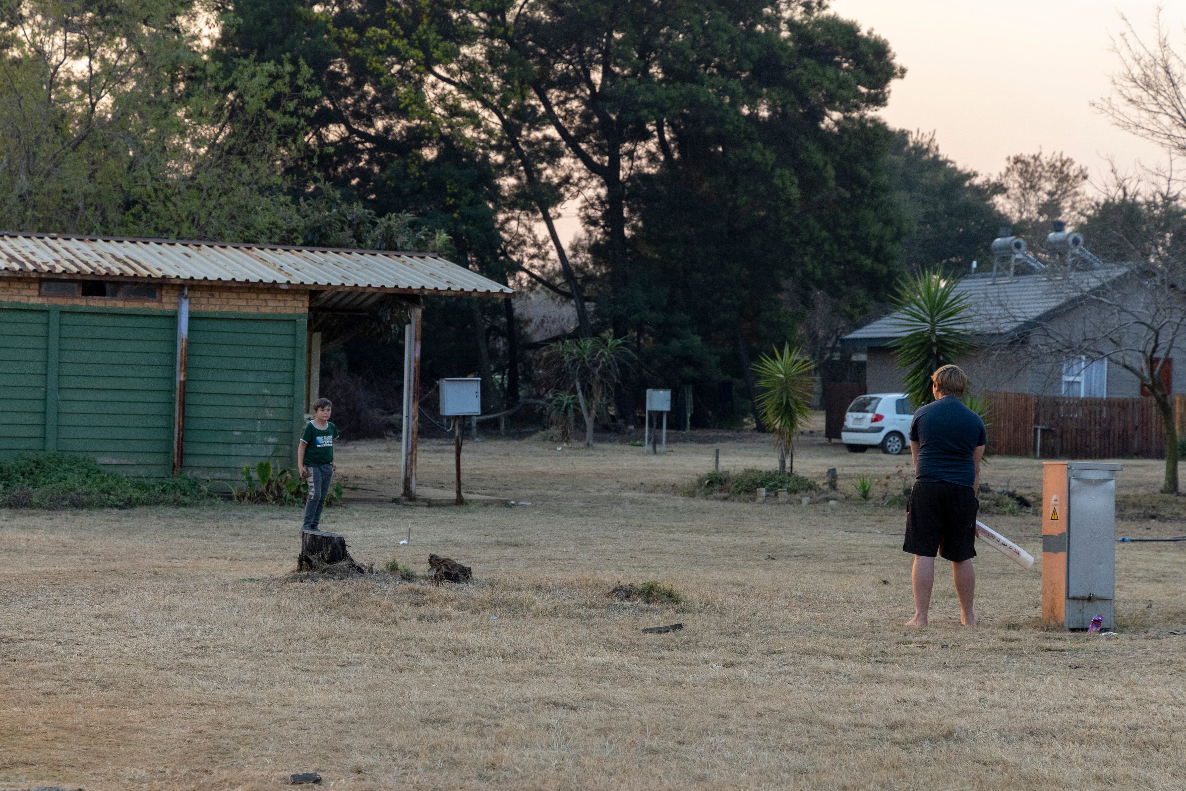 Dos niños juegan con un bate de béisbol en Kleinfontein, en Pretoria, el 8 de julio de 2026.