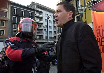 Un <i>ertzaina</i> impide a Arnaldo Otegi participar en un mitin de AuB ayer en Tolosa.