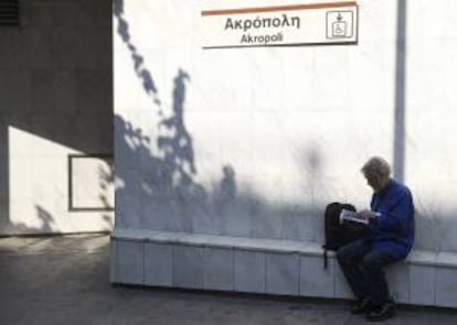 Un hombre lee un libro en la salida de una estación de metro cerrada durante una jornada de huelga. EFE/Archivo