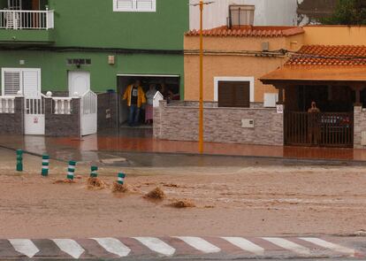 Hasta ahora, la isla de Gran Canaria es la que más lluvias ha recibido, con cuatro estaciones por encima de los 100 litros por metro cuadrado en las últimas 12 horas, dos de ellas en la capital, Las Palmas de Gran Canaria. En la foto, varias personas se protegen de la lluvia en el garaje de una vivienda en Pozo Izquierdo, Gran Canaria.