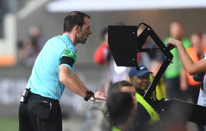 Un árbitro revisa una jugada en un Ausburgo-Borussia.