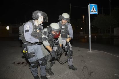 Un agente de policía israelí herido recibe ayuda durante los enfrentamientos en la mezquita. La Media Luna Roja habilitó un hospital de campaña para atender a los heridos, muchos por impactos de balas de goma y granadas de estruendo.