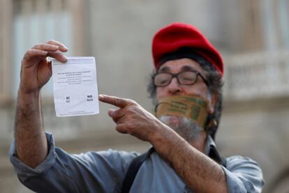 Un hombre muestra una de las papeletas utilizadas en el referéndum en Plaza Sant Jaume de Barcelona, durante una protesta convocada por grupos pro-independentistas.