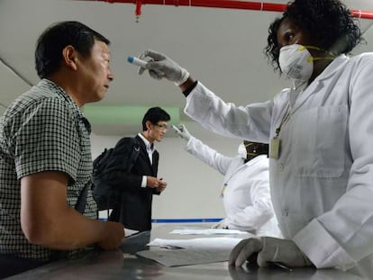 Passageiro tem a temperatura retirada no aeroporto do Qu&ecirc;nia.