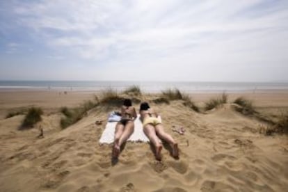 Dos bañistas en las dunas de Camber Sands Beach, en East Sussex (Inglaterra).