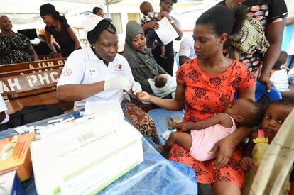 Una sanitaria extrae sangre a una madre para detectar un posible caso de paludismo en Ajah, un distrito de Lagos, Nigeria, el país del mundo con mayor incidencia.