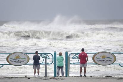 Turistas observam força das ondas na costa de Ormond Beach, na Flórida.