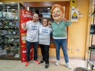 Los propietarios del estanco de El Vendrell que ha vendido íntegramente el primer premio de la Grossa de Cap d'Any, con la cabezuda que es imagen del premio, de Loteries de Catalunya.